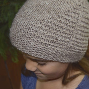 Child wearing Aviary Hat Pattern knit in rose gray